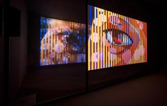 Ho Tzu Nyen, T for Time, 2023–ongoing, 2-channel synchronized HD videos (16:9, colour, and eight-channel sound, approximately 60 min), voile screen, scrim walls, real-time algorithmic editing and compositing system. Installation view at Singapore Art Museum, 2023.